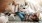 overhead view of  a woman texting as she lies on a couch with a dog at her feet