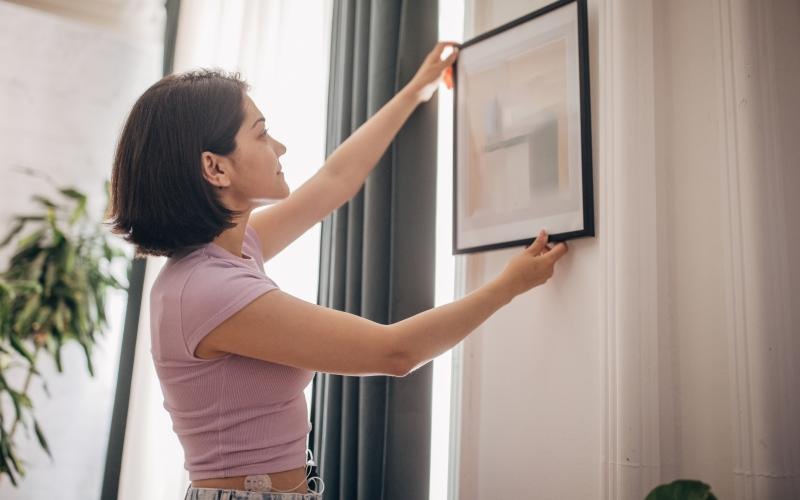 a person hanging a picture
