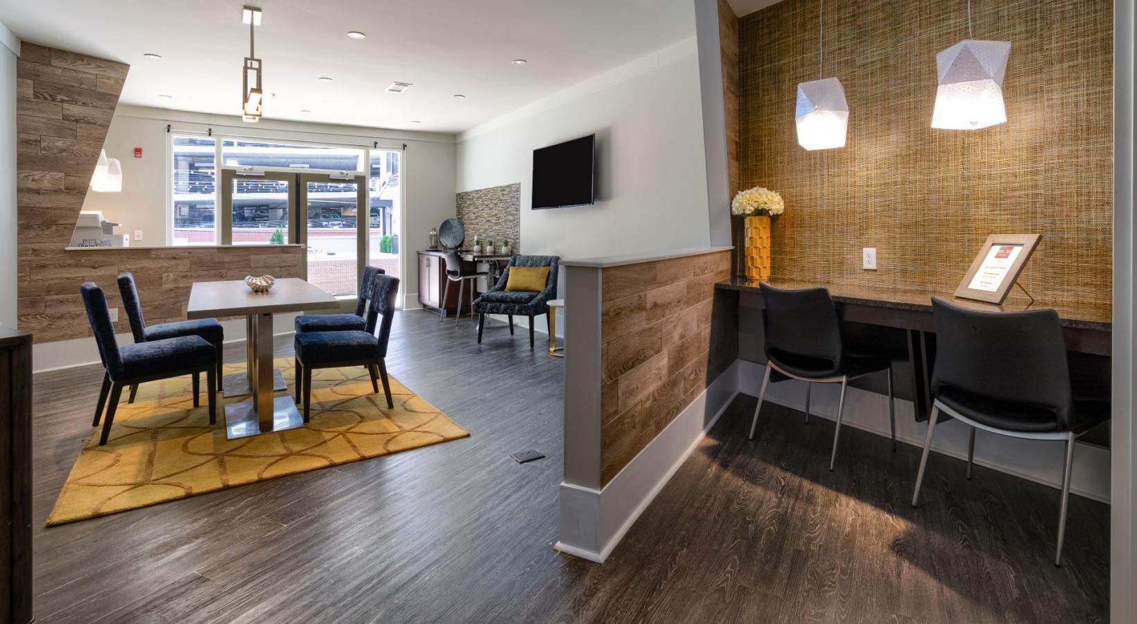 Settle into comfort at Artisan on 18th a room with a table chairs and a tv