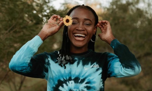 A beautiful community at the heart of all your passions woman holds a flower in her hair in a park