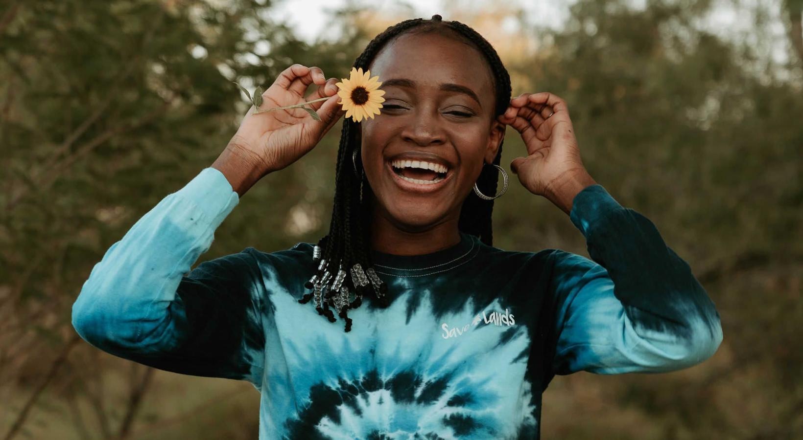 A beautiful community at the heart of all your passions woman holds a flower in her hair in a park