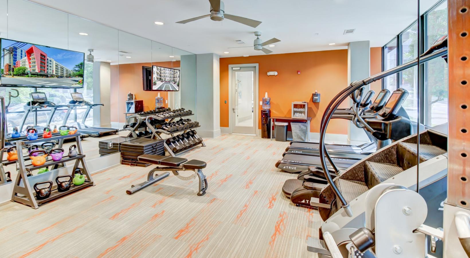 Relax and recharge in beautiful and spacious bedrooms a room with exercise equipment and kettle bells