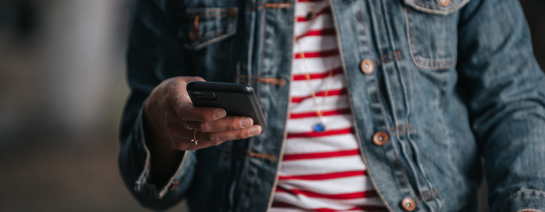a woman in a stripped shirt holding a phone