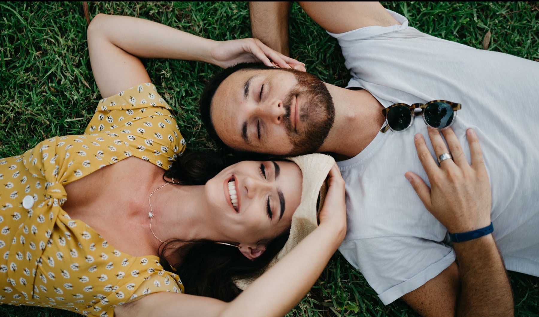 a man and woman lying in the grass